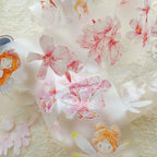 Decorative paper with pink flowers and fairy illustrations on a textured background