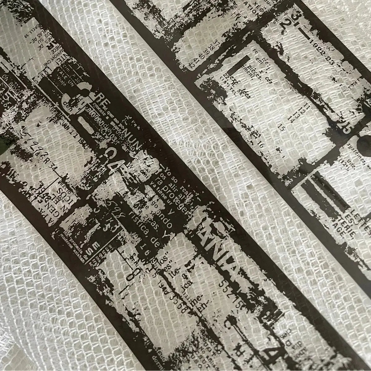 Close-up of Film Noir 04 Black PET Tape printed text and patterns on a textured surface