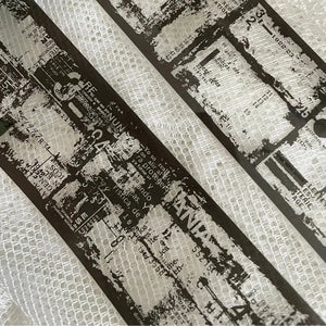 Close-up of Film Noir 04 Black PET Tape printed text and patterns on a textured surface
