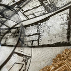 Close-up of a vintage-style map with text and a compass, featuring a gold decorative element.