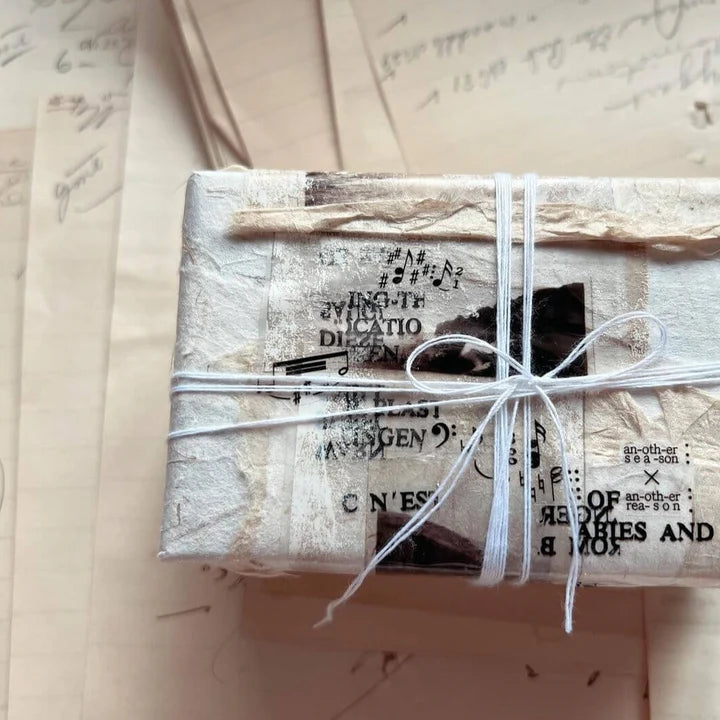 Gift wrapped in newspaper and string styled with Film Noir 06 PET Tape on a textured surface
