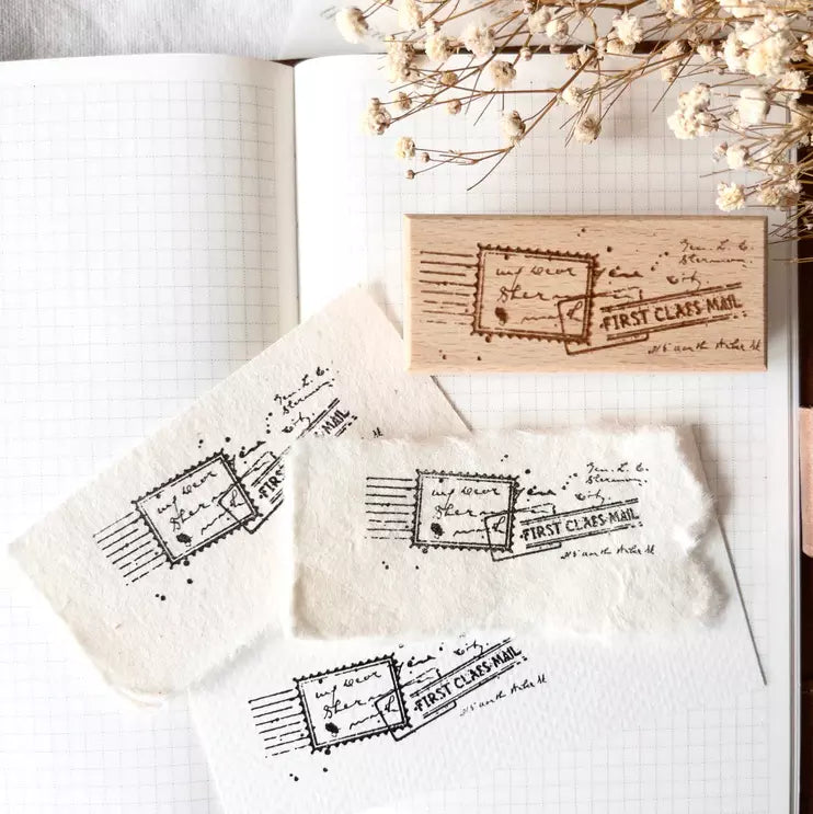 First Class Mail Rubber Stamp with its postal design print on white with paper and flowers