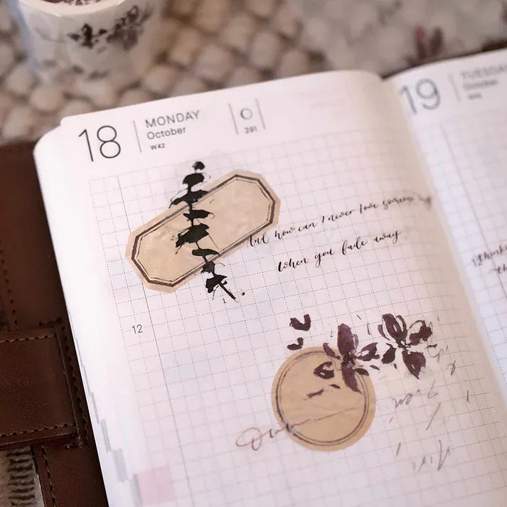 Open notebook decorated with Floral PET Tape flower stickers and script text on a textured surface