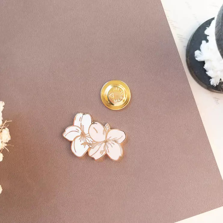 Floral Magnetic Charm with a gold magnetic button displayed together on a pink surface