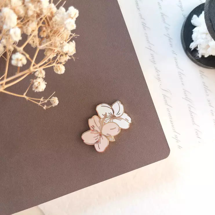 Pair of Floral Magnetic Charms on a brown surface with dried flowers in the background