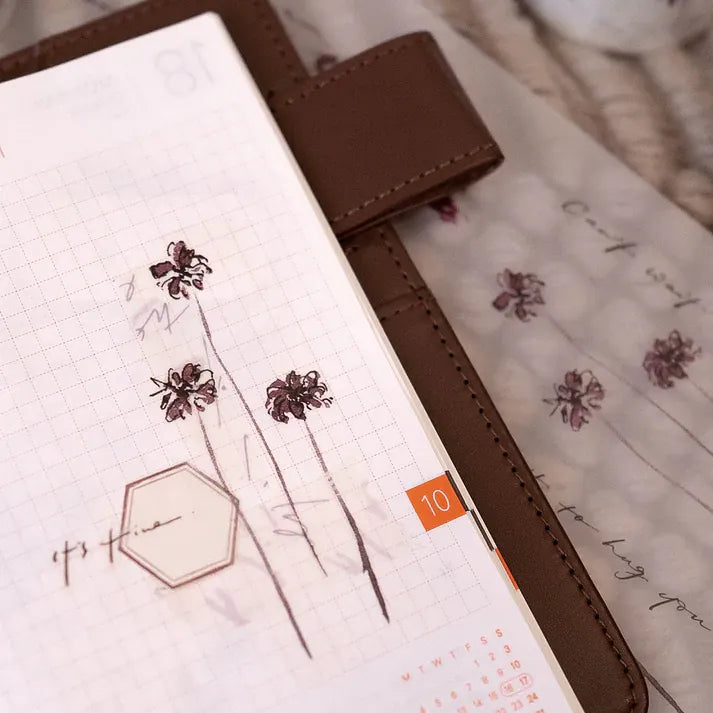 Close-up of a gridded planner decorated with watercolor Floral PET Tape flower designs by Jr. Journal