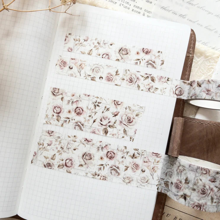 French Romance Floral Washi Tape unrolled with a wooden spool on a textured surface