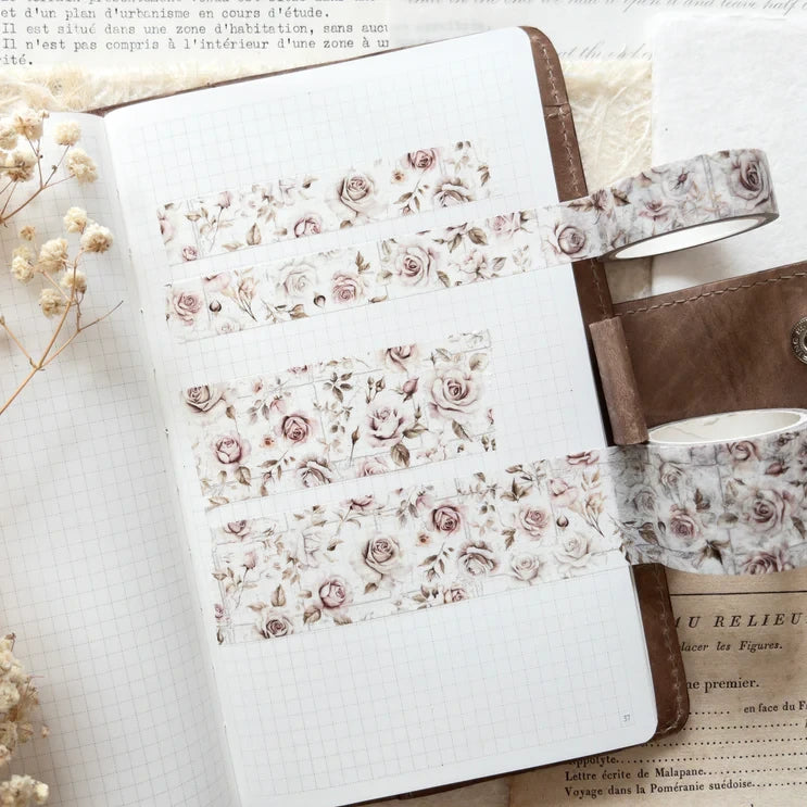 Floral notebook wrapped with a French Romance Floral Washi Tape band on a white surface