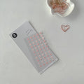 Floral sticker sheet with a heart-shaped paperclip on a light gray background