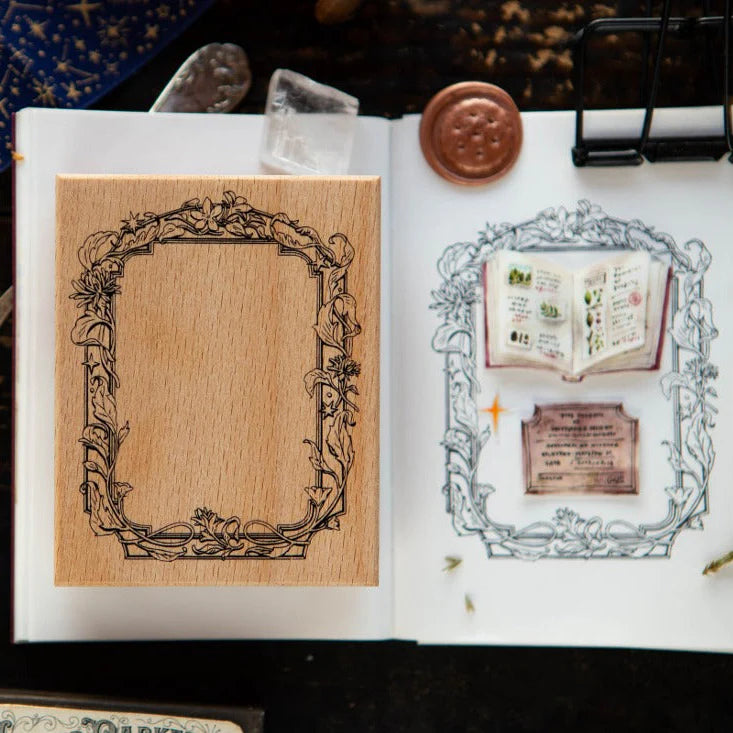 Flower Frame B Rubber Stamp impressions in an open book of botanical frames on a dark backdrop