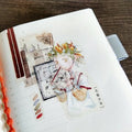 Decorative notebook with artistic illustrations on a wooden surface