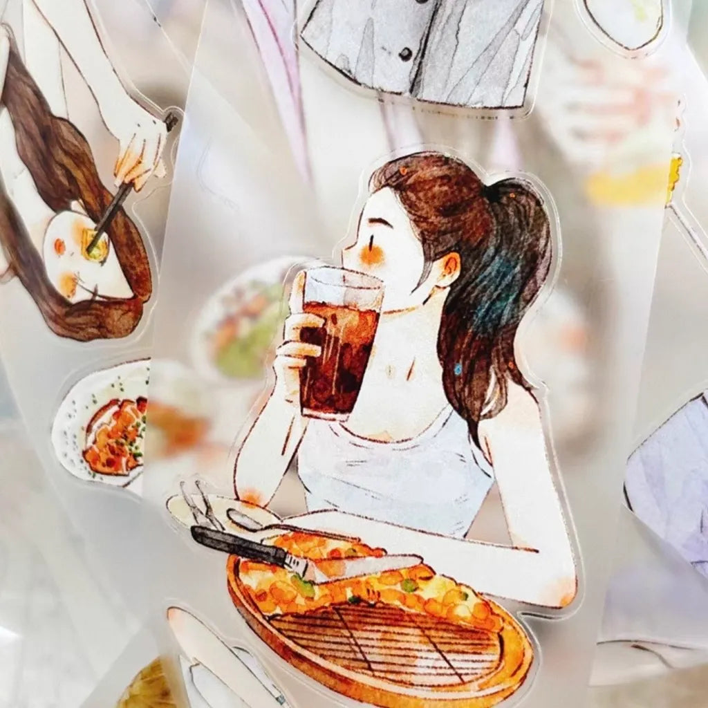 A close-up of a transparent acrylic sheet decorated with watercolor-style illustrations of a woman drinking from a glass, a pizza, and other food and clothing scenes.
