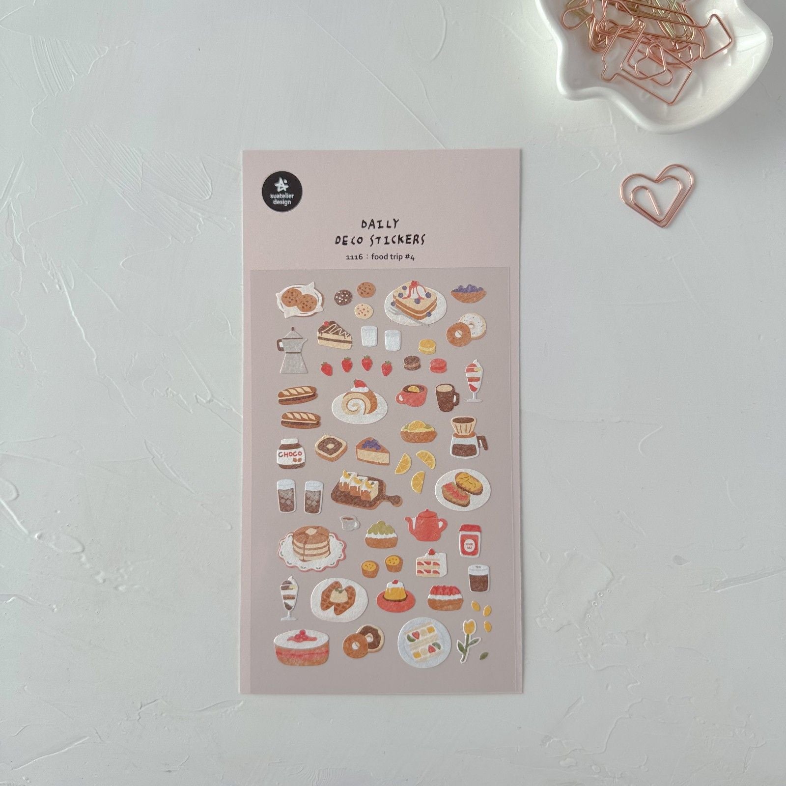 Sheet of decorative stickers with food-themed designs on a light surface.