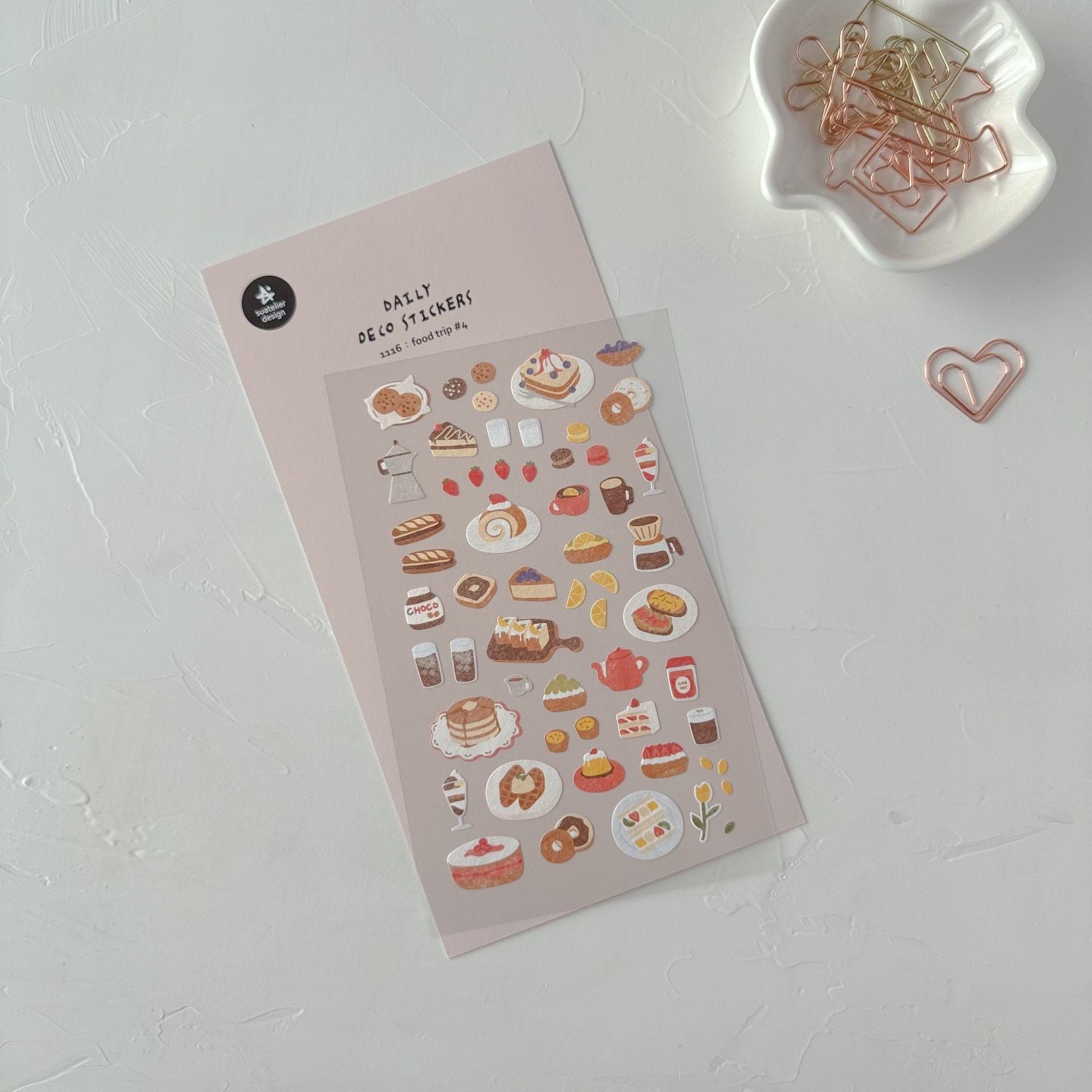 Sheet of decorative stickers with food-themed designs on a white surface.