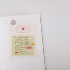 Notebook with stickers featuring illustrations and text on a white background