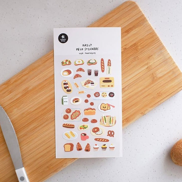 Sheet of food-themed stickers on a wooden cutting board with a knife.
