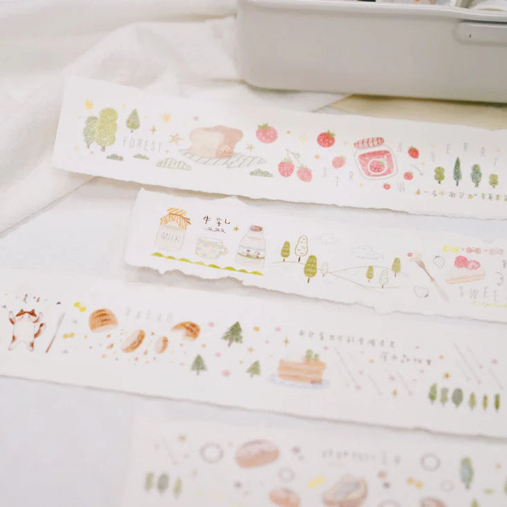 Strips of Forest Bakery PET Tape bakery illustrations arranged on a white surface, top view