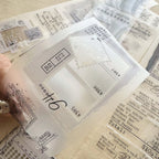 Collection of clear stamps with various designs and text on a textured surface.