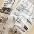 Clear stamp set with various text and design stamps on a beige background