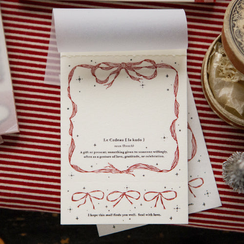 Card with red decorative elements on a striped surface