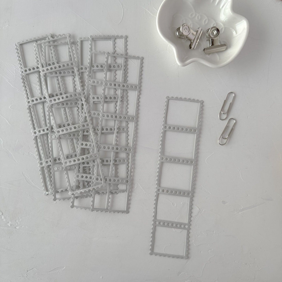 Grey Frames Vol. 1 film-strip style frame cards with a container of clips on light grey