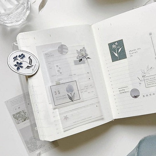 Open notebook decorated with Cicada Shigure PET Tape stickers on a light surface