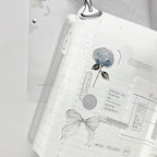 Open notebook with floral design and text on a white background