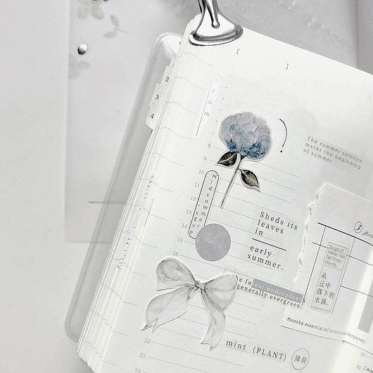 Open notebook decorated with a Cicada Shigure PET Tape floral design and text on white