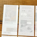 White cards with text and minimal graphics on a wooden surface