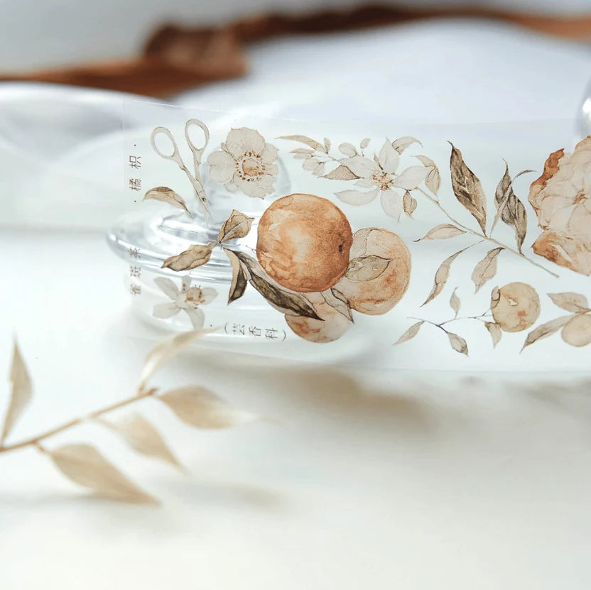 Clear bottle decorated with Tangerine PET Tape floral and citrus motifs on white