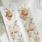 Two white towels with floral and fruit design on a white background