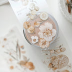 Cosmetic container with pressed flowers on a floral-patterned surface