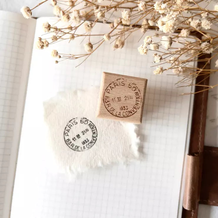 French Postal Rubber Stamp with Paris 60 design on a notebook page with dried flowers