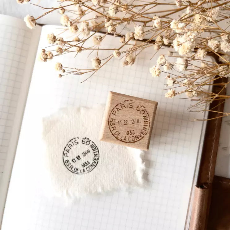 Two French Postal Rubber Stamp impressions on paper with dried flowers in the background