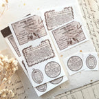 Vintage French label sticker sheet with typography, botanical illustrations, and cut-out labels on textured paper background