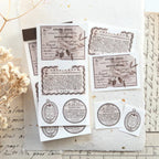Aesthetic flat lay of vintage-style French label stickers with handwritten paper and dried flowers