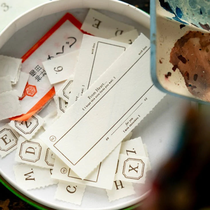 White cards with letters and numbers on a white plate