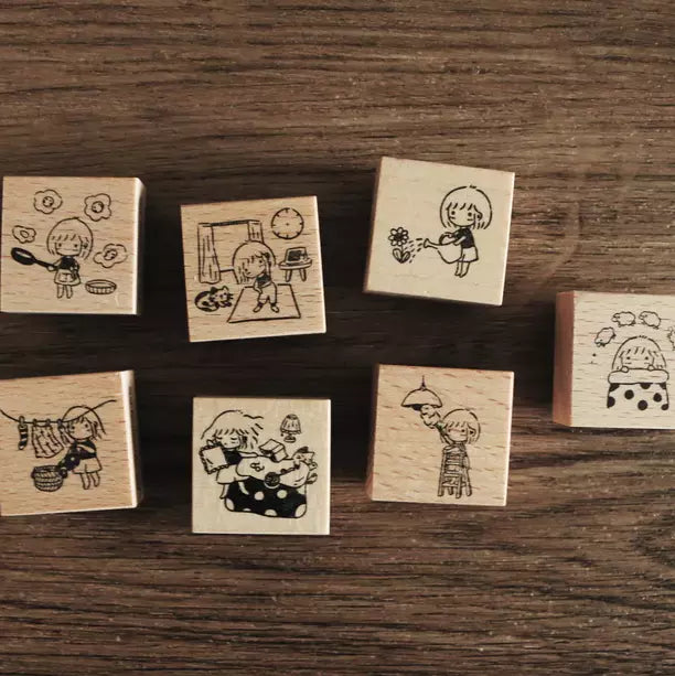 Full set of Mini Girls At Home wooden stamps with daily-life illustrations on a wooden desk
