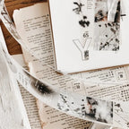 Decorative paper with text and floral elements on a wooden surface
