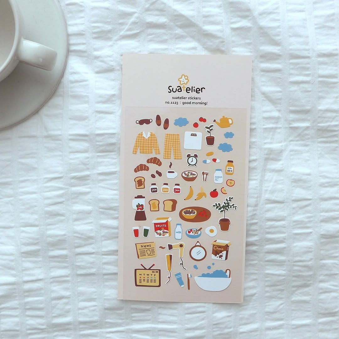 Sticker sheet with illustrations on a textured white surface next to a cup.