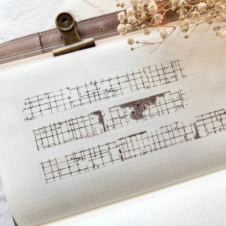 Sheet of music with stenciled patterns on a clipboard with dried flowers.
