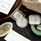 Vintage-style product packaging with labels and a small bottle on a dark surface.