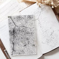 Open notebook with textured pages on a wooden surface