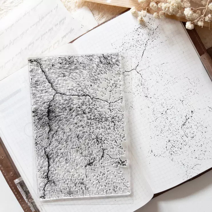 Open notebook with Grunge Background Clear Stamp distressed texture impressions on a wooden desk
