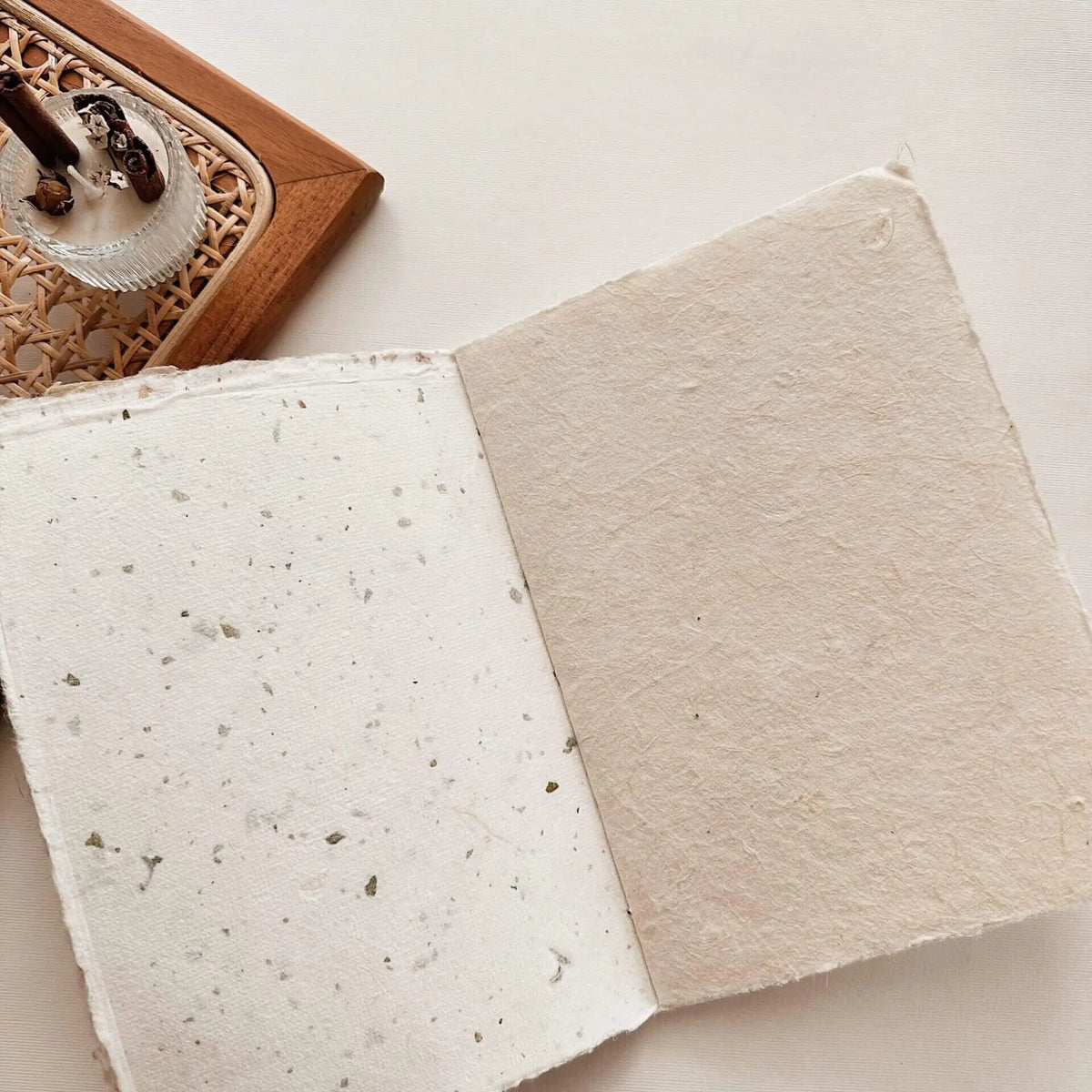 Handmade Paper A6 Notebook natural fiber pages with a wooden coaster in the background