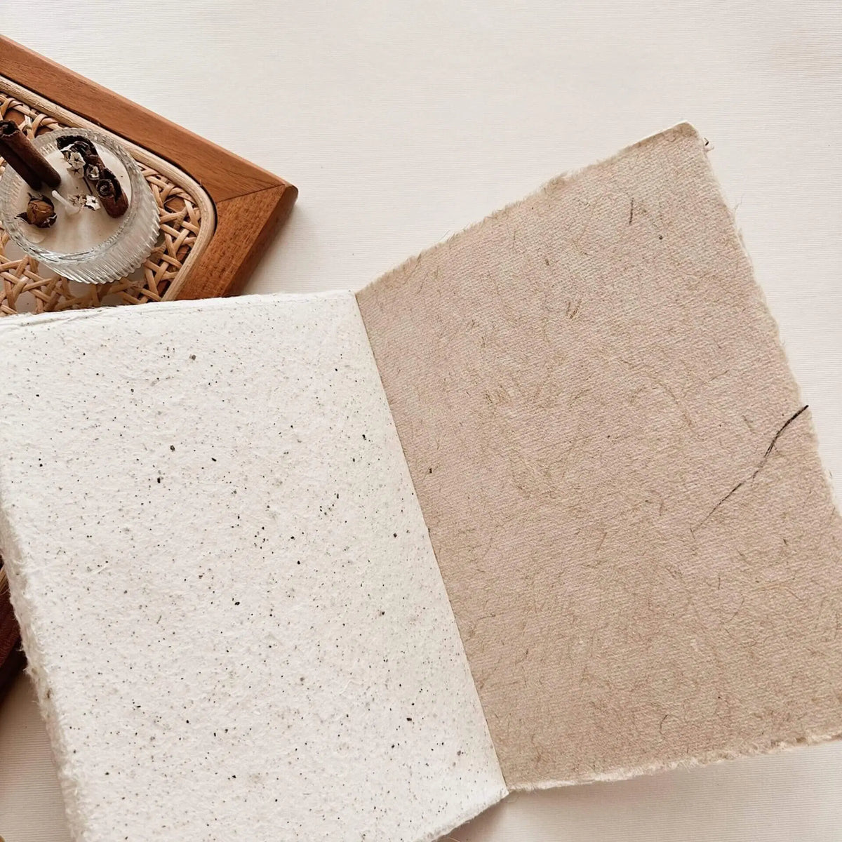 Two square textured Handmade Paper A6 Notebook sheets displayed on a light surface