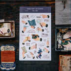 Sheet of decorative stickers with various hand illustrations on a dark wooden surface.