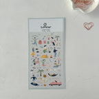 Sheet of decorative stickers with illustrations on a light gray background, featuring the brand 'Suatelier'.