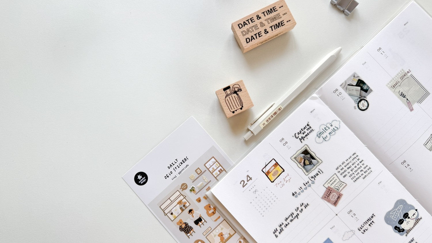 Planners with stamps and a pen on a white surface