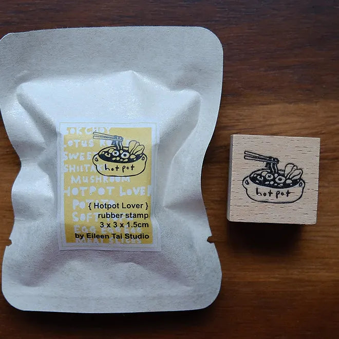 Hotpot-themed rubber stamp and packaging on a wooden surface